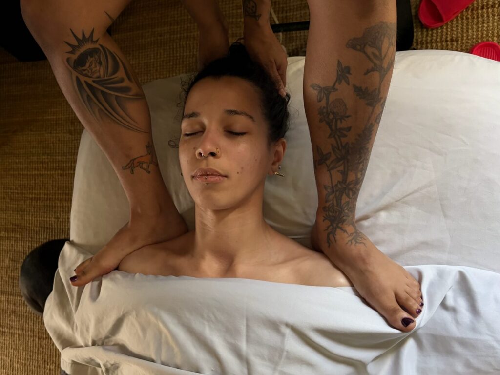 woman getting scalp massage with hands and neck massage with feet